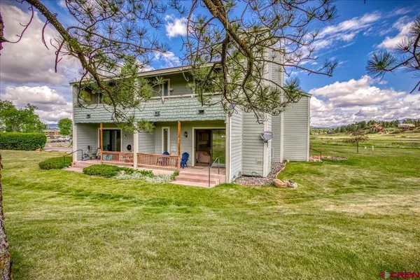 a view of a house with a yard and sitting area