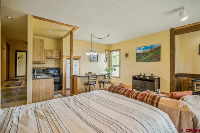 a bedroom with a bed and a view of kitchen