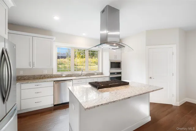 a kitchen with granite countertop a stove a sink and a refrigerator