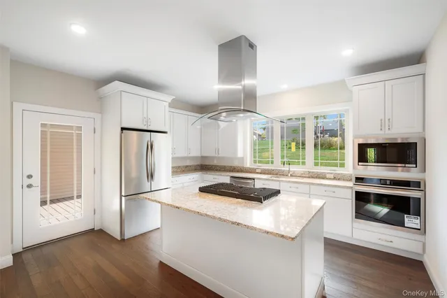 a kitchen with a refrigerator a stove a microwave and island