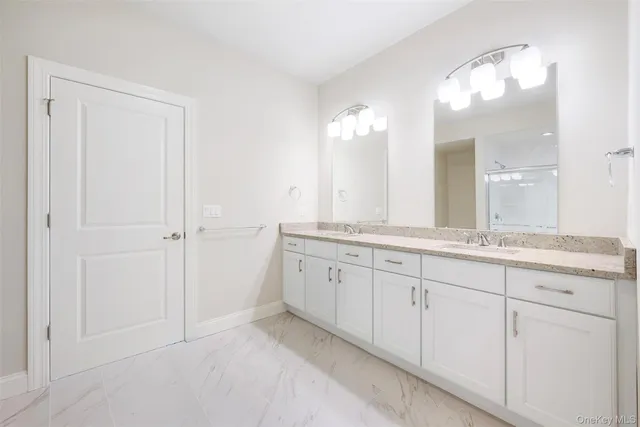 a bathroom with a granite countertop sink two mirror and a