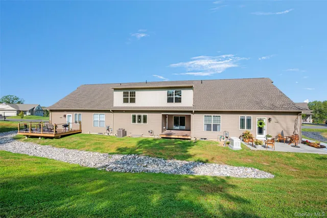 a view of a house with a swimming pool and a lawn chairs next to a yard