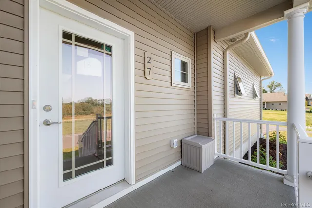 a view of a porch with a door and wooden floor
