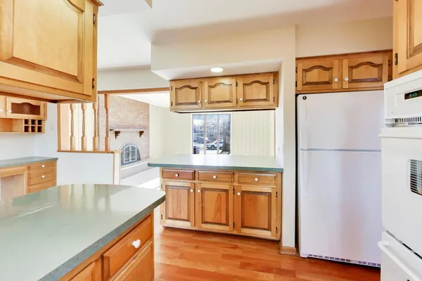 a kitchen with stainless steel appliances granite countertop a refrigerator a stove and a sink with wooden floor