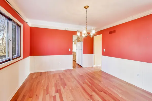 a view of a room with wooden floor staircase and a kitchen
