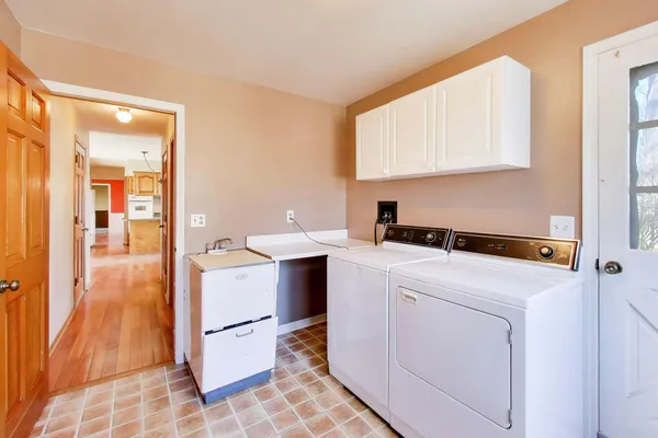 a view of washer and dryer with bathroom in the background