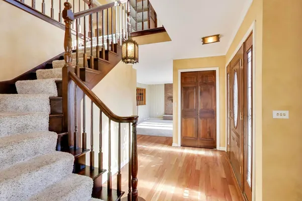 a view of staircase with lots of frames on wall and a window