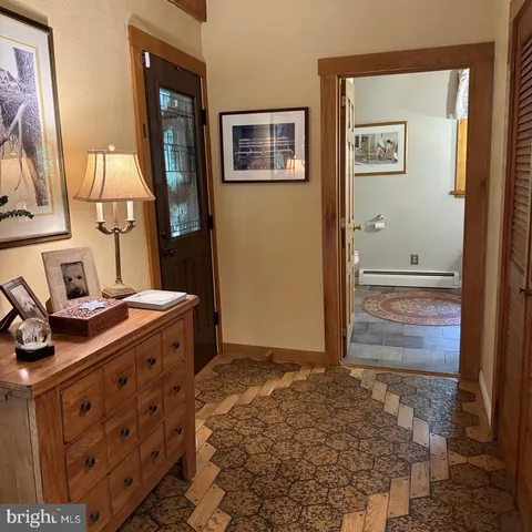 a bedroom with a bed lamp and paintings on the wall