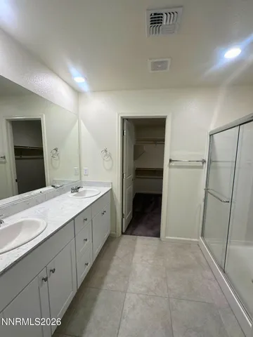 a spacious bathroom with a double vanity sink a and mirror