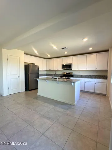 a large kitchen with stainless steel appliances granite countertop a stove top oven a sink and a granite counter top