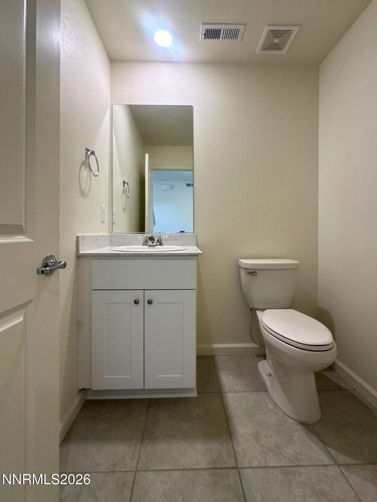 9007 Quail Grove Drive Reno, NV 89506 - Photo 6 of 18 a bathroom with a toilet a sink and mirror