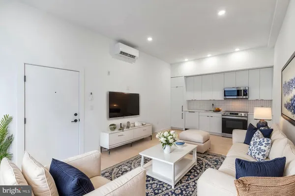 a living room with furniture a rug and a flat screen tv