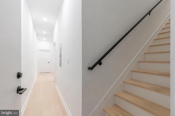 a view of a hallway with wooden floor and entryway