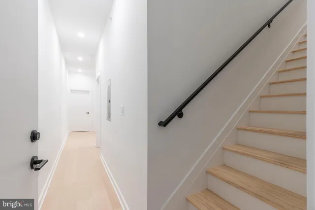 a view of a hallway with wooden floor and entryway