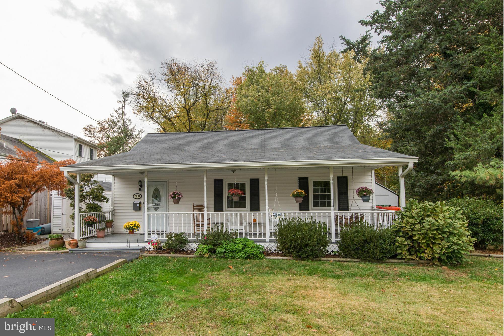 a view of a house with a yard plants and large tree