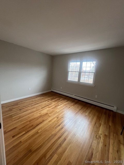 79 Beths Avenue, Unit 100 Bristol, CT 06010 - Photo 21 of 29 an empty room with wooden floor and windows