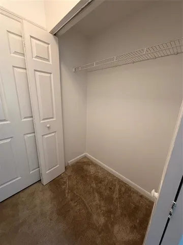 an empty room with windows and ceiling fan