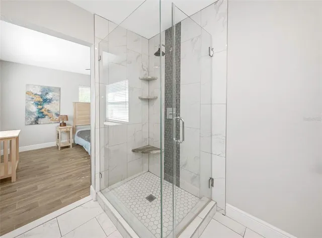 a bathroom with a glass shower door and a bathtub