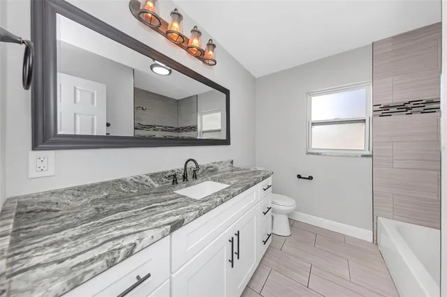 a bathroom with a granite countertop sink mirror and a