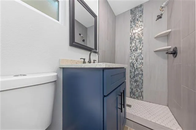 a bathroom with a sink a toilet and shower