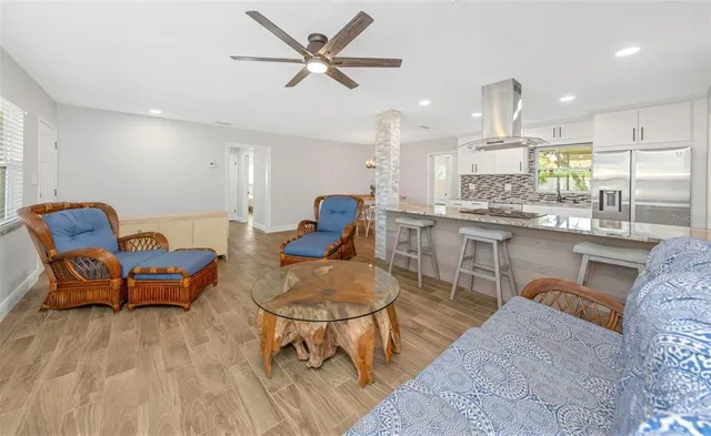 a living room with furniture a rug and kitchen view