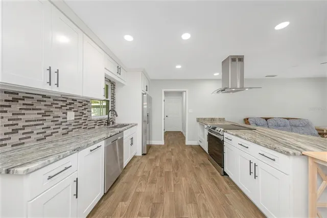 a large kitchen with a stove top oven and cabinets
