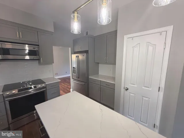 a view of an empty room with wooden floor and windows