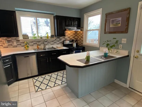 a kitchen with stainless steel appliances a sink window and cabinets