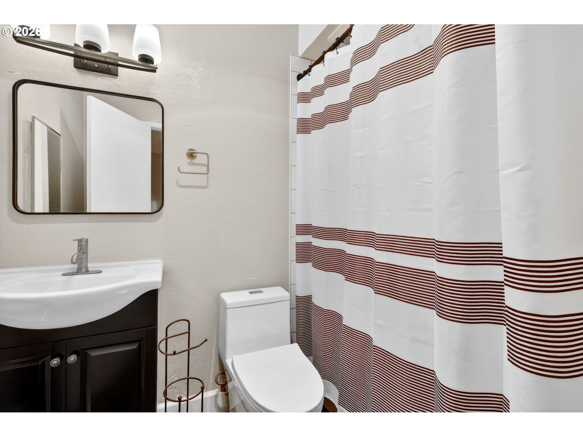 4 Touchstone, Unit 151 Lake Oswego, OR 97035 - Photo 20 of 28 a bathroom with a sink a toilet a mirror and shower curtain