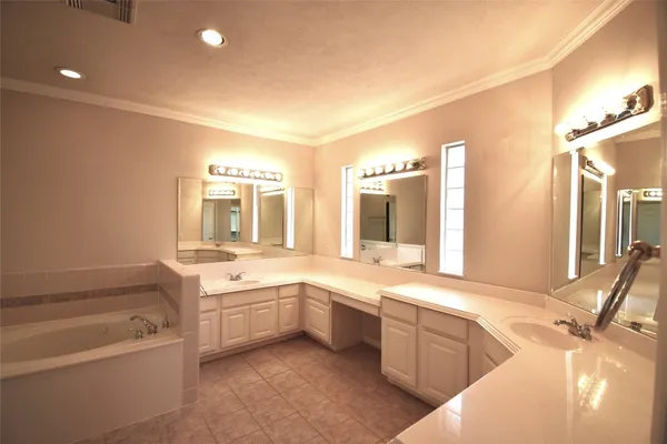 a bathroom with a tub sink and mirror