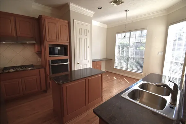 a kitchen with granite countertop a sink and a refrigerator