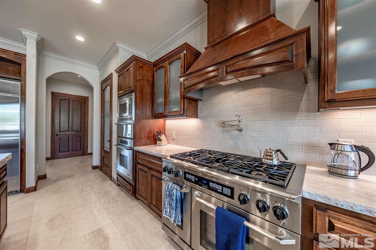12835 Silver Wolf Road Reno, NV 89511 - Photo 11 of 31 a kitchen with stainless steel appliances granite countertop a stove and a refrigerator