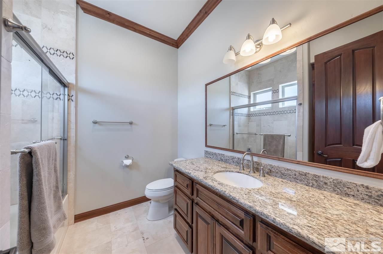 12835 Silver Wolf Road Reno, NV 89511 - Photo 27 of 31 a bathroom with a granite countertop sink a toilet and shower