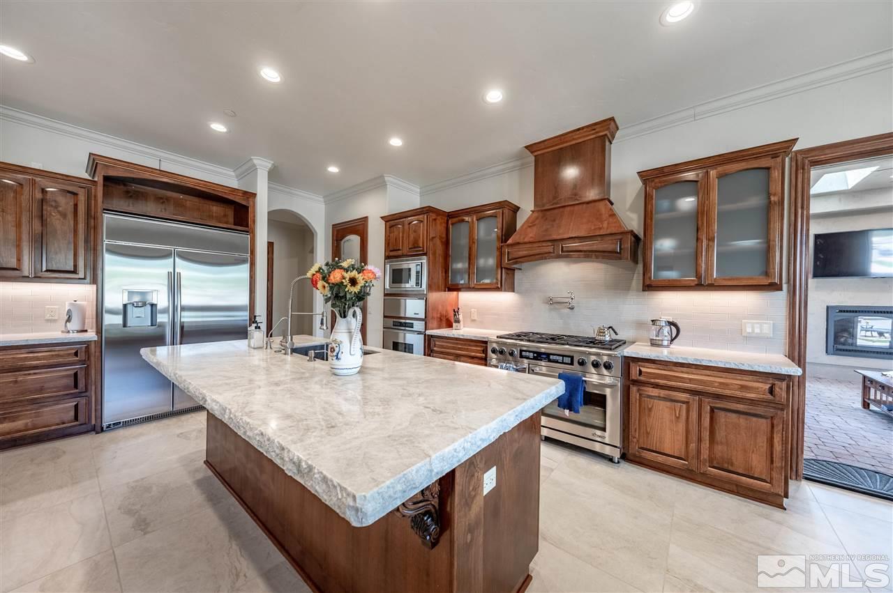 12835 Silver Wolf Road Reno, NV 89511 - Photo 9 of 31 a kitchen with stainless steel appliances granite countertop a stove top oven a sink and a refrigerator