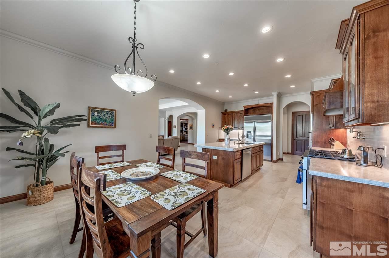 12835 Silver Wolf Road Reno, NV 89511 - Photo 10 of 31 a living room with furniture a chandelier and a dining table