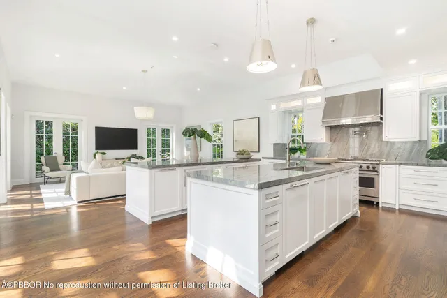 a large kitchen with stainless steel appliances kitchen island granite countertop a stove and a view of living room