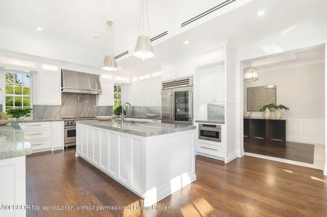 a kitchen with stainless steel appliances kitchen island granite countertop a stove a sink and a refrigerator