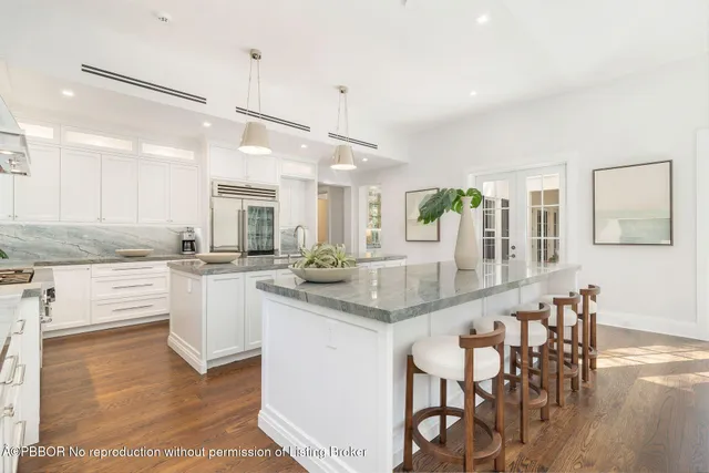 a kitchen with stainless steel appliances granite countertop a kitchen island a stove a table and chairs in it