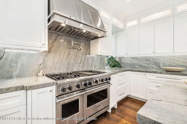 a kitchen with a stove and white cabinets