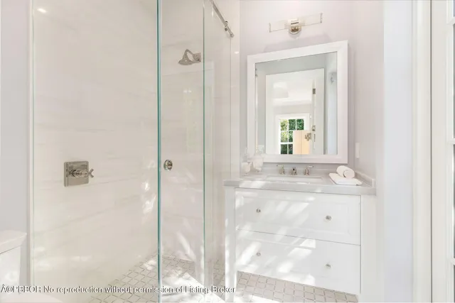 a bathroom with a granite countertop sink a mirror and a shower