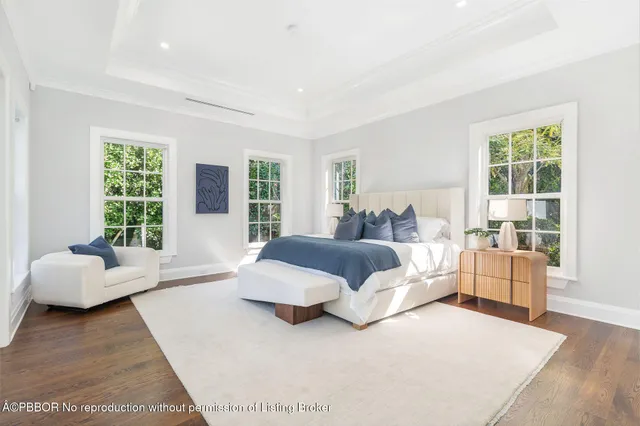 a spacious bedroom with a bed and glass window