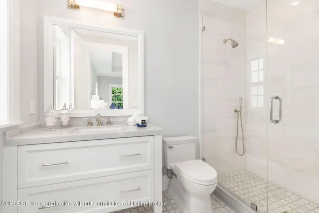 a bathroom with a granite countertop toilet sink and a mirror
