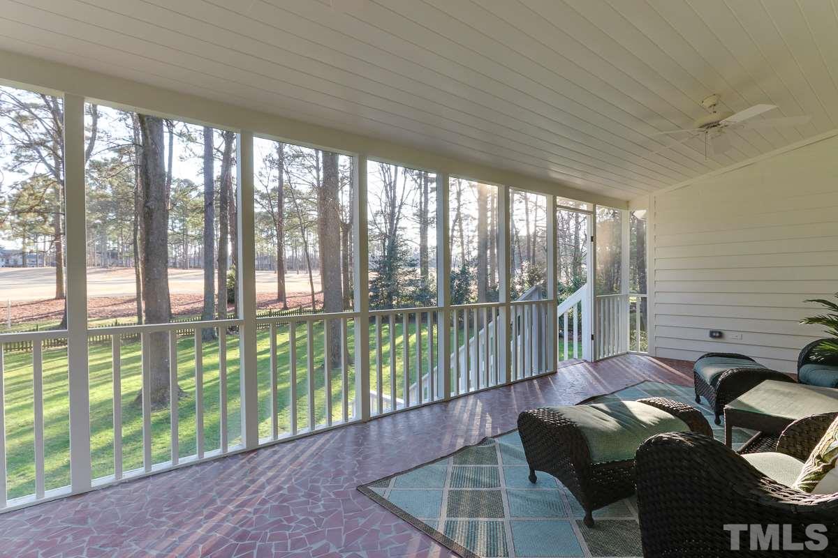 7009 North Ridge Drive Raleigh, NC 27615 - Photo 22 of 25 Large screened porch overlooking backyard with mature trees and golf course.