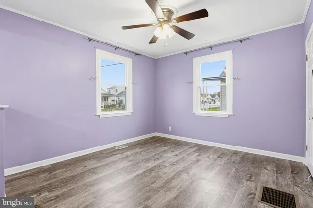 a view of empty room with wooden floor