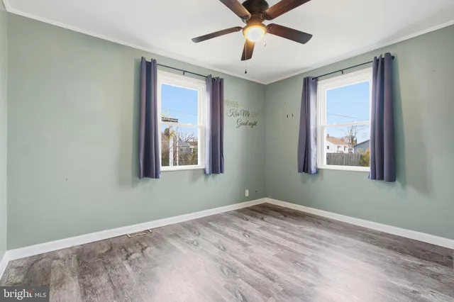 a view of empty room with window and ceiling fan