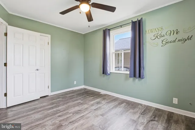 a view of empty room with window and ceiling fan
