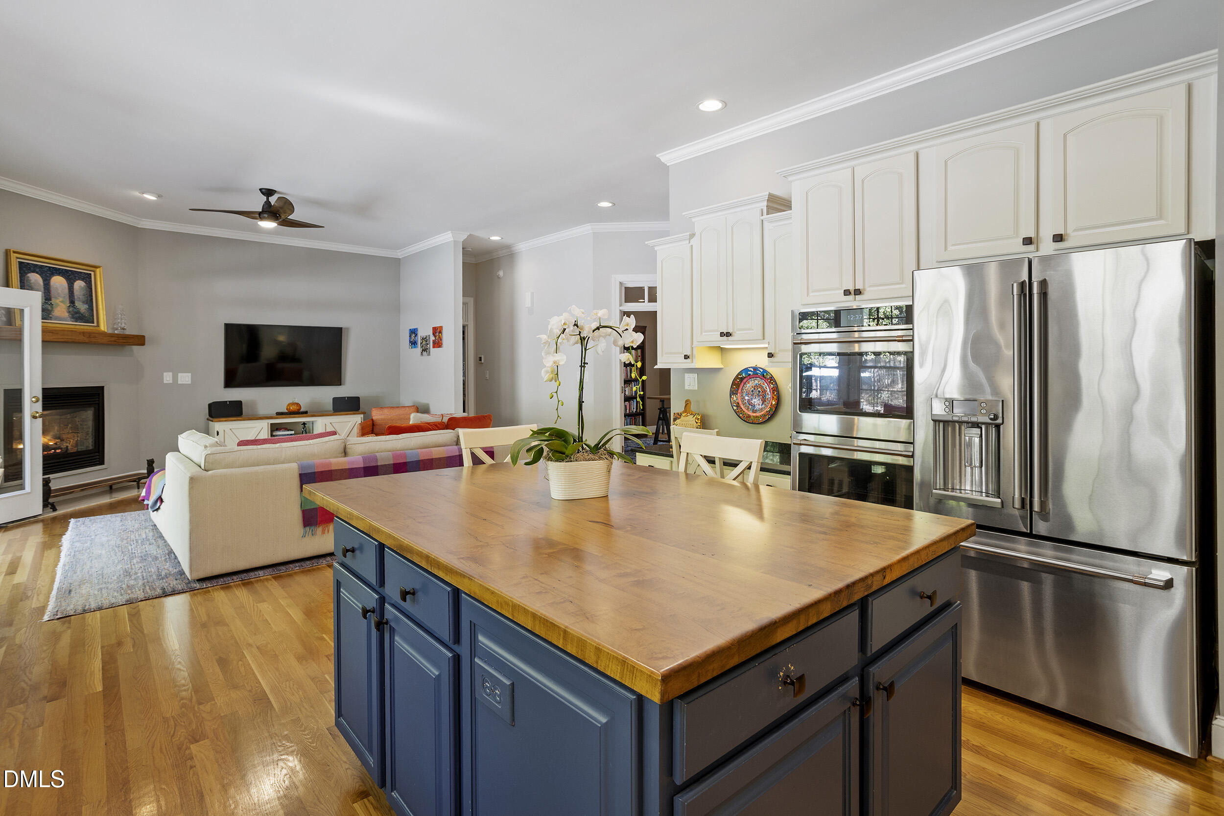 905 Olde Thompson Creek Road Apex, NC 27523 - Photo 23 of 67 a kitchen with stainless steel appliances a stove a refrigerator a sink a dining table and chairs with wooden floor