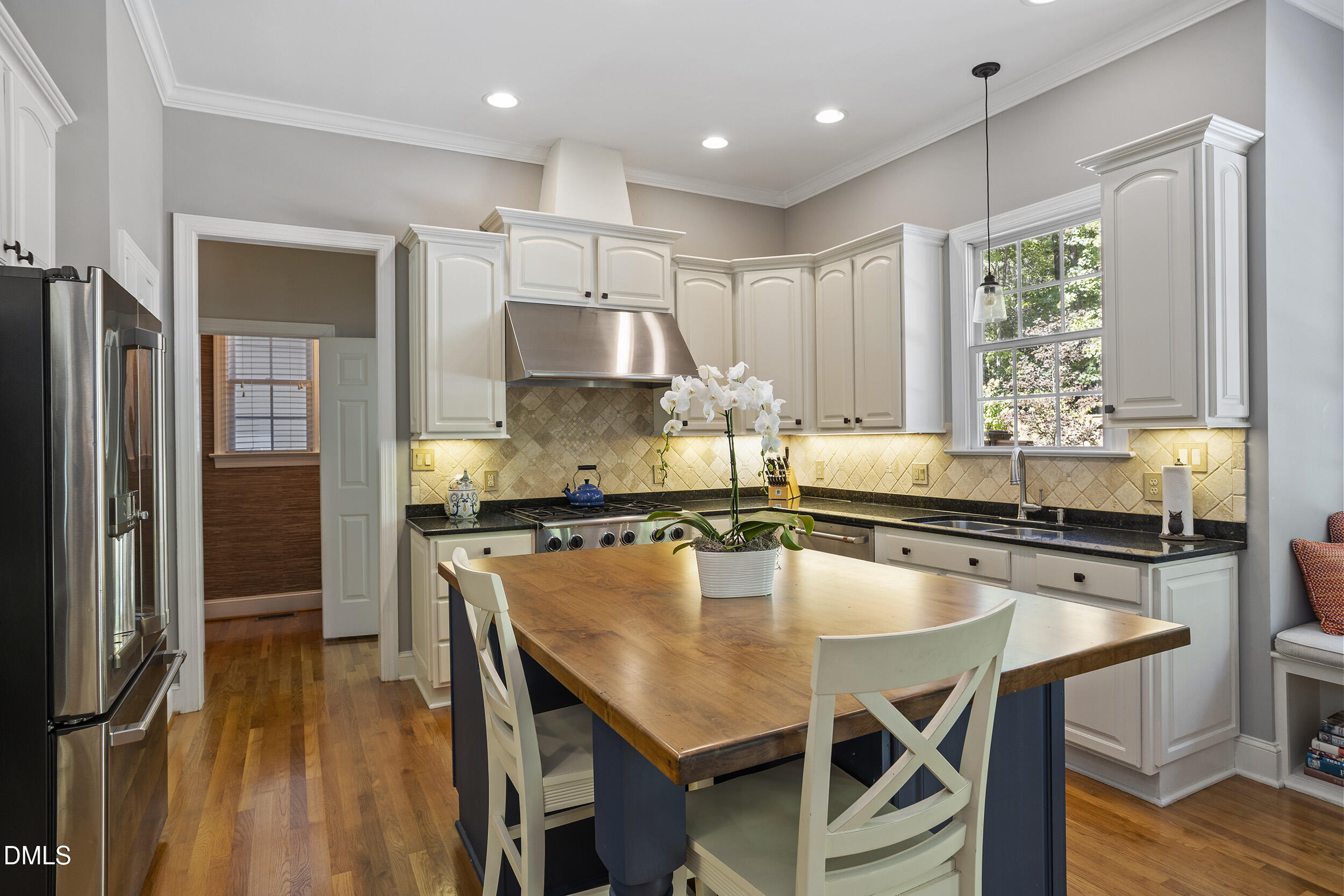 905 Olde Thompson Creek Road Apex, NC 27523 - Photo 25 of 67 a kitchen with kitchen island granite countertop a stove a sink a refrigerator and wooden cabinets