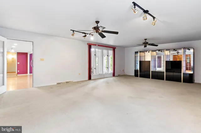 a view of a livingroom with a ceiling fan window and stairs