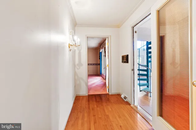 a view of a hallway with wooden floor and furniture